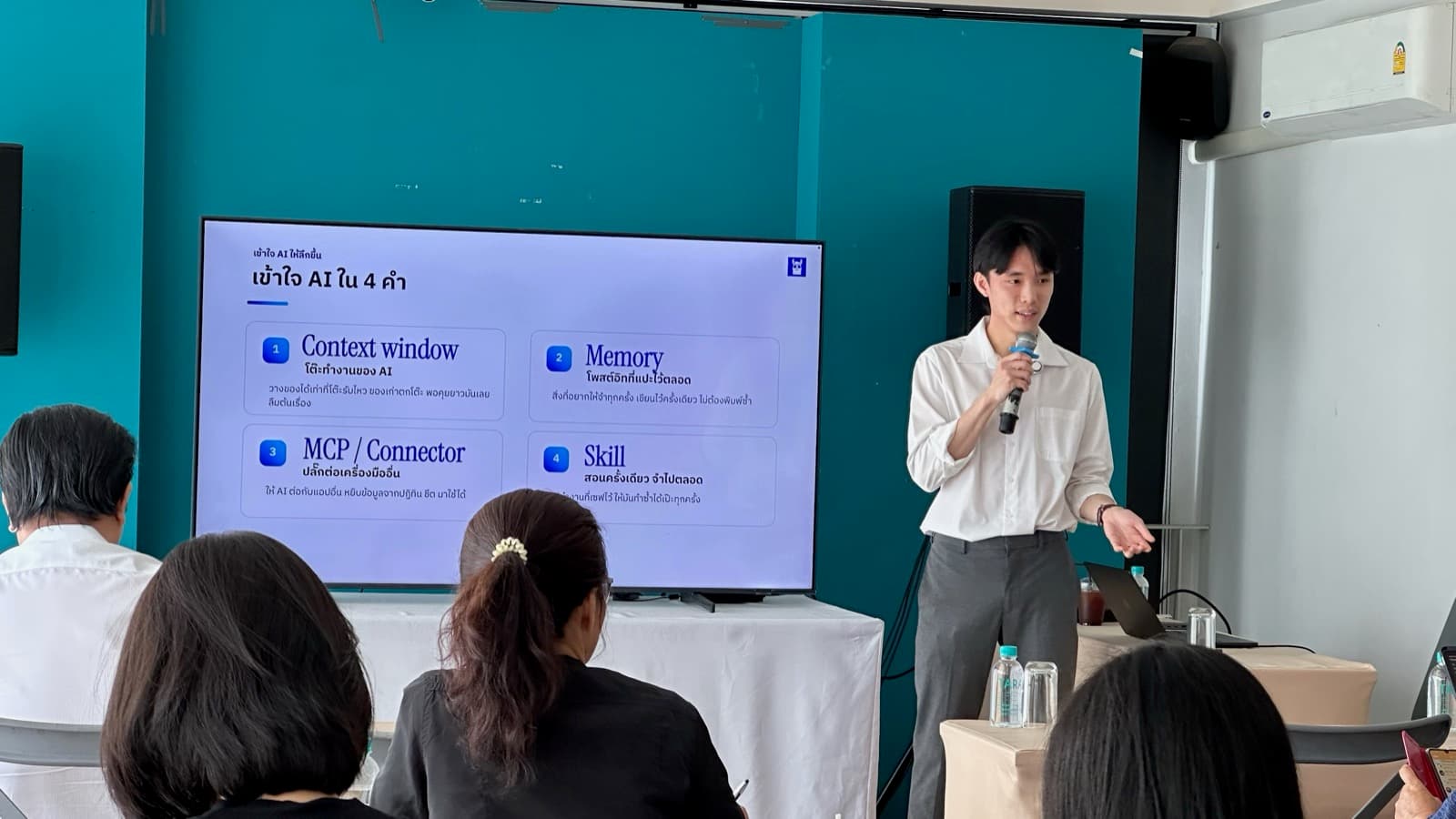 ผู้สอนอธิบายสไลด์ เข้าใจ AI ใน 4 คำ ให้ผู้เข้าอบรมฟัง